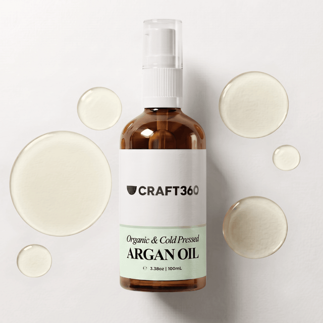 100 ml bottle of Certified Organic Argan Oil surrounded by pools of golden carrier oil